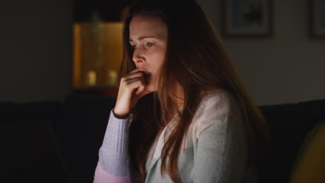 Anxious-Woman-Sitting-On-Sofa-At-Home-At-Night-Looking-At-Laptop-Concerned-About-Social-Media-Or-Bad-News-11